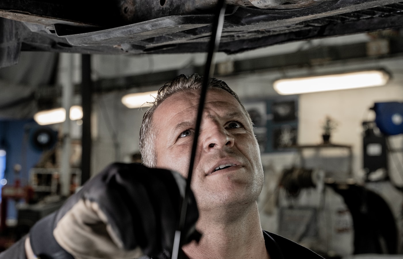 Mechanic working on a car inside an automotive workshop